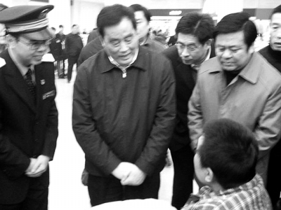 盛光祖在候车大厅询问旅客王忠山“车票好不好买”。